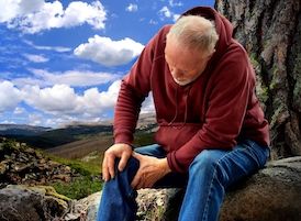 Man dealing with bursitis pain in his knee while on a hike